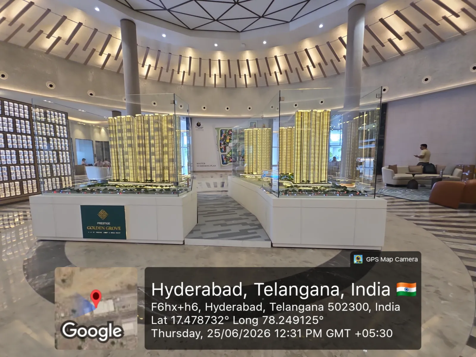 Prestige Golden Grove Experience Centre — Master Township Model (June 2026) Interior of the Prestige Golden Grove experience centre showing the master township scale model on display with project branding, Velimela, Hyderabad, June 2026.